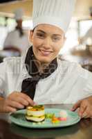 Portrait of female chef finishing dessert plates