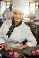 Portrait of smiling female chef finishing dessert plates