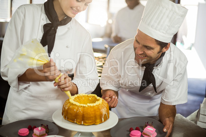 Two chefs preparing a cake