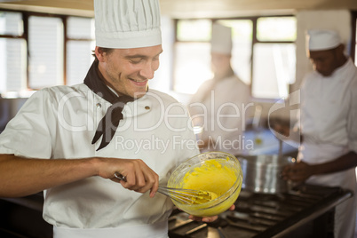 Smiling chef mixing dough