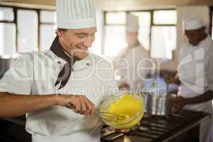 Smiling chef mixing dough