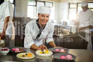 Portrait of female chef finishing dessert plates