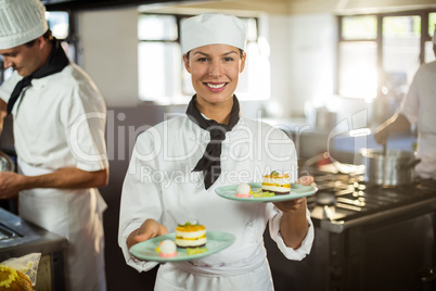 Portrait of chef presenting dessert plates