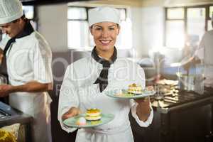 Portrait of chef presenting dessert plates