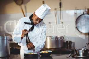 Chef sprinkling pepper on a meal