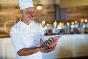 Smiling chef using digital tablet