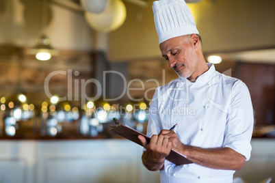 Chef writing on a clipboard