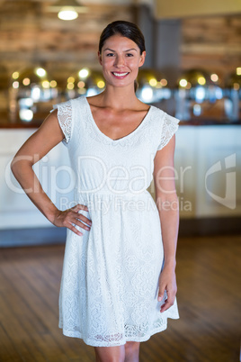 Portrait of smiling woman standing with hand on hip