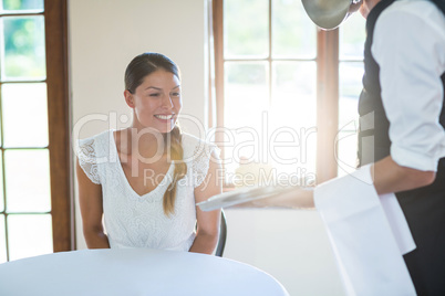 Waiter serving food to women in restaurant