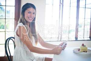 Portrait of smiling woman using a digital tablet in restaurant