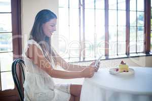 Smiling woman using a digital tablet in restaurant
