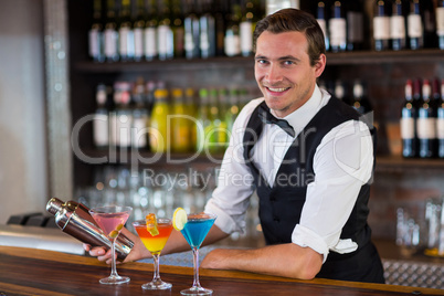 Bartender mixing a cocktail drink in cocktail shaker