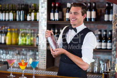 Bartender mixing a cocktail drink in cocktail shaker