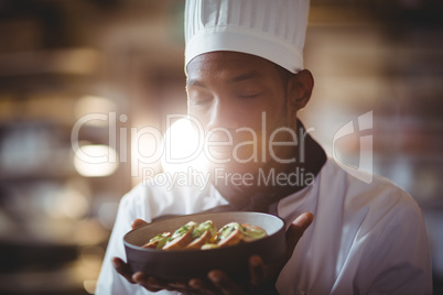 Close-up of chef with eyes closed smelling food