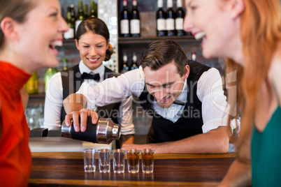 Bartender pouring tequila into shot glasses