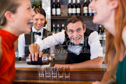 Bartender pouring tequila into shot glasses