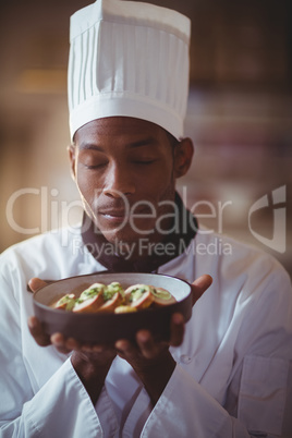 Close-up of chef with eyes closed smelling food