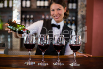 Portrait of bartender pouring a red wine in the glass