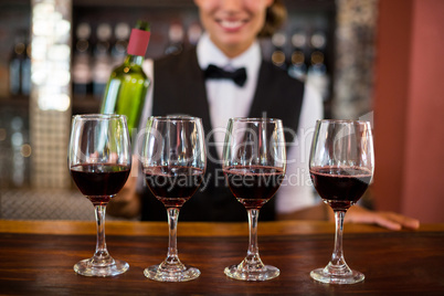 Four glasses of red wine ready to serve on bar counter