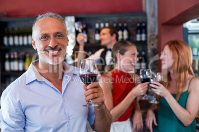 Portrait of smiling man holding glass of red wine