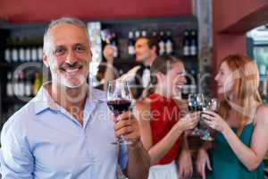 Portrait of smiling man holding glass of red wine