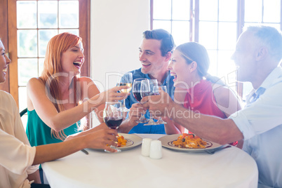 Friends toasting wine glass while having meal