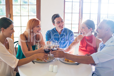 Friends toasting wine glass while having meal