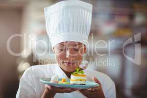 Female chef with eyes closed smelling food