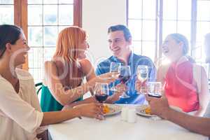 Friends holding wine glass while having meal
