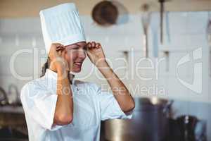 Chef adjusting her hat