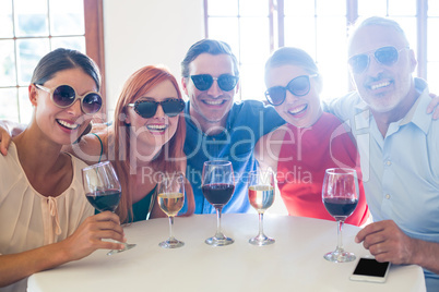 Group of friends in sunglasses posing with drinks