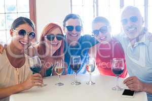 Group of friends in sunglasses posing with drinks