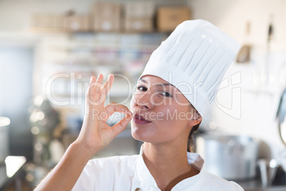 Portrait of female chef making ok sign