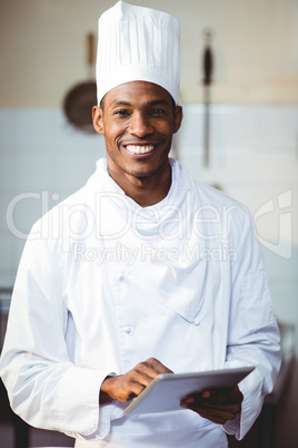Portrait of smiling chef using digital tablet