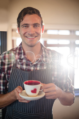 Close-up of waiter holding a coffee cup at counter