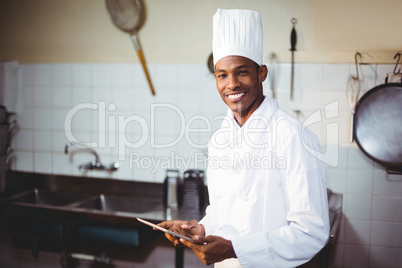 Portrait of smiling chef using digital tablet