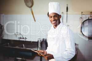 Portrait of smiling chef using digital tablet