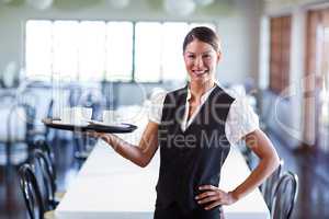 Portrait of smiling waitress holding a tray of coffee cups