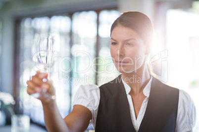 Waitress holding up a empty wine glass