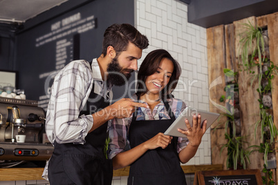 Two waiters using a tablet computer