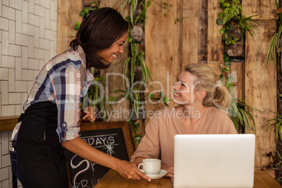 Waitress serving a coffee to a customer