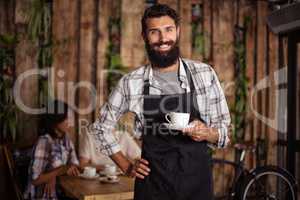 Portrait of a waiter with a cup of coffee