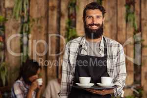 Waiter holding a tray with coffees