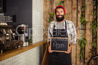 Waiter holding a board written open