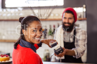 Seller taking payment with bank card reader and smartphone