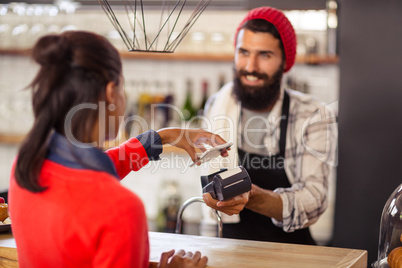 Seller taking payment with bank card reader and smartphone
