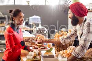 Seller serving a cake to the customer