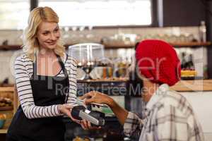 Customer paying by bank card reader with his smartphone