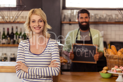 Portrait of two casual waiters holding a board written open
