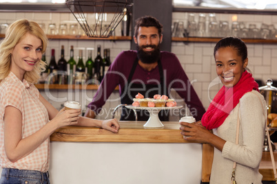 Bartender with customers holding a cup of coffee